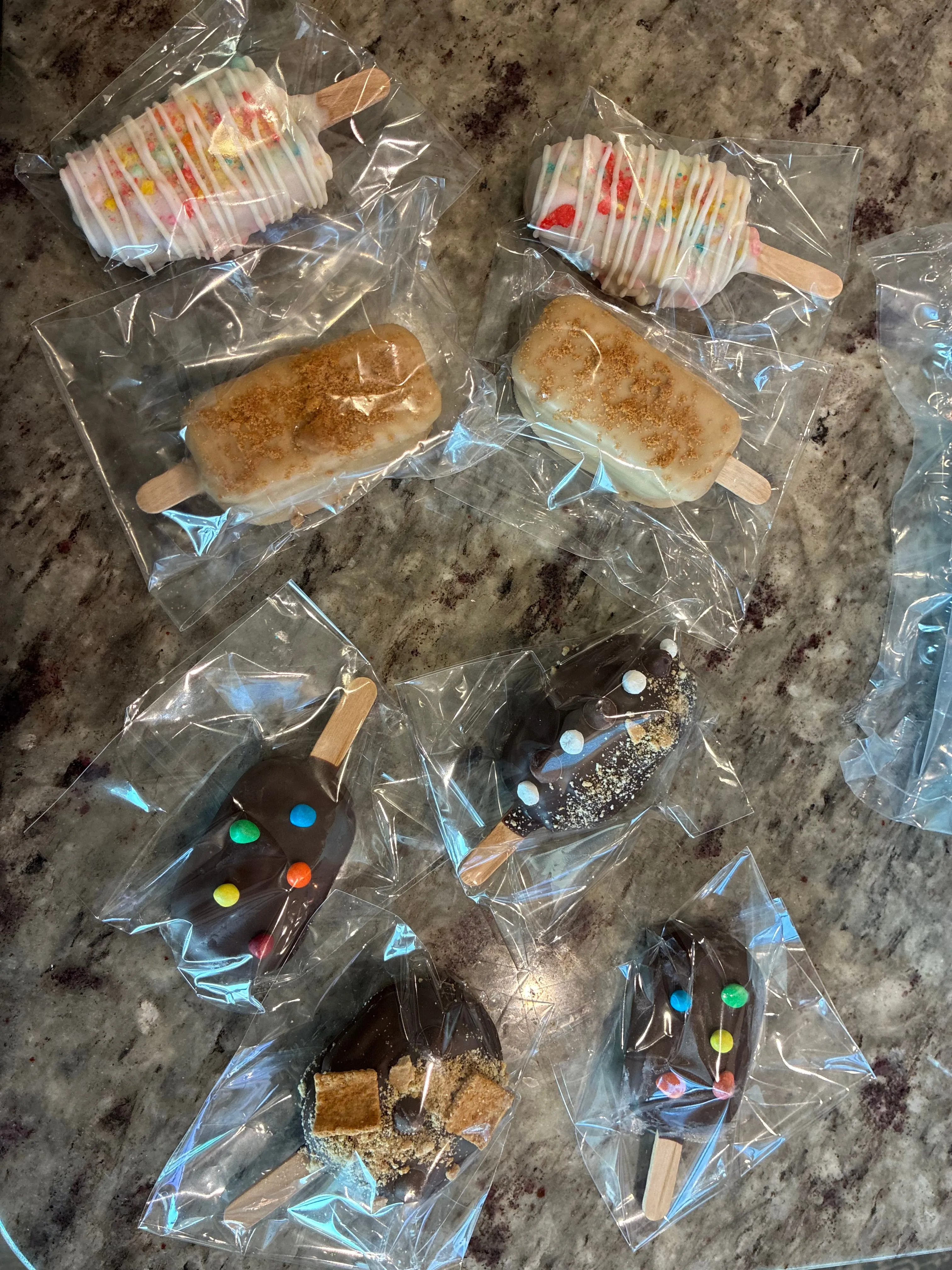 A mixed order of individually bagged cakesicles including Fruity Pebbles, Biscoff, Cosmic Brownie and S’mores